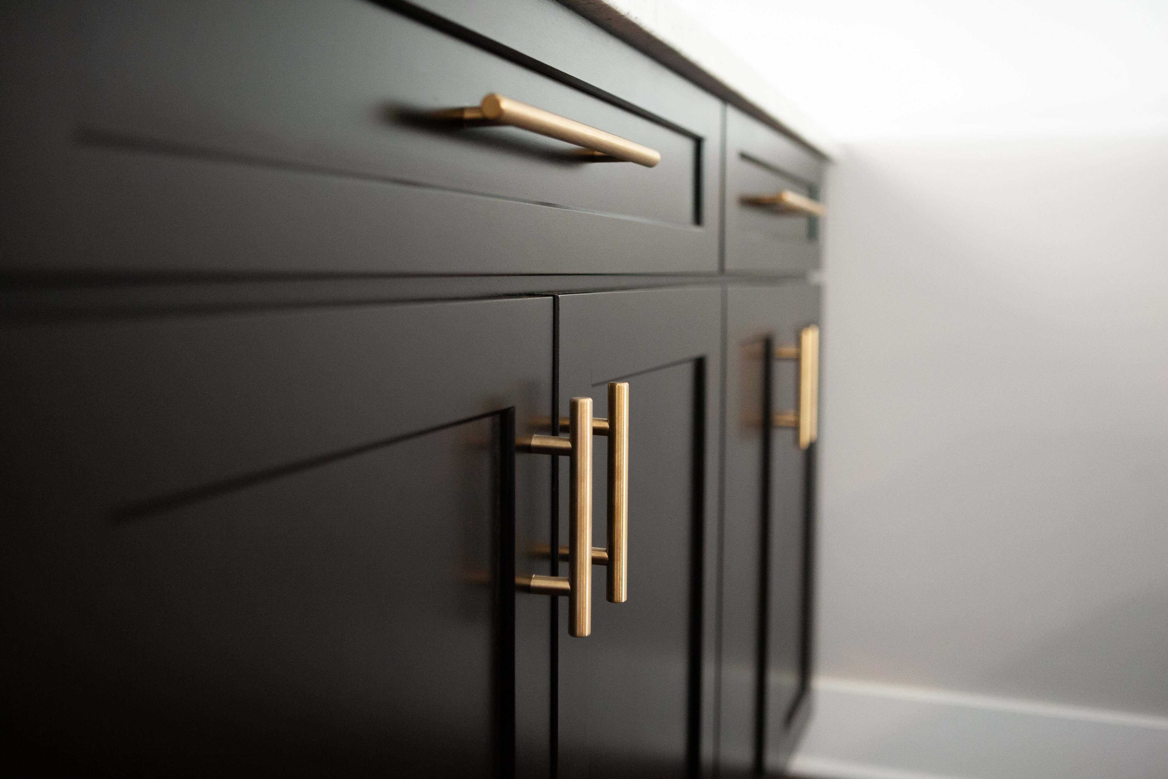 Basement Finish in Andover: Dark cabinets with gold handles 